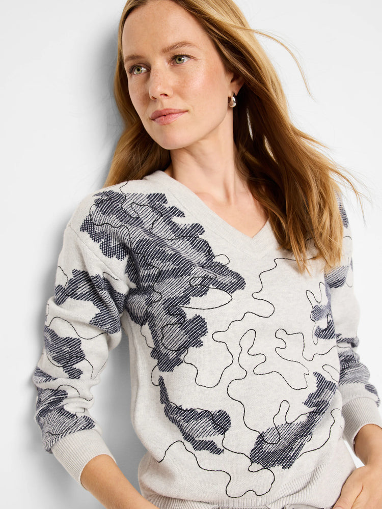 Light gray V-neck sweater with a dark gray/navy abstract pattern.