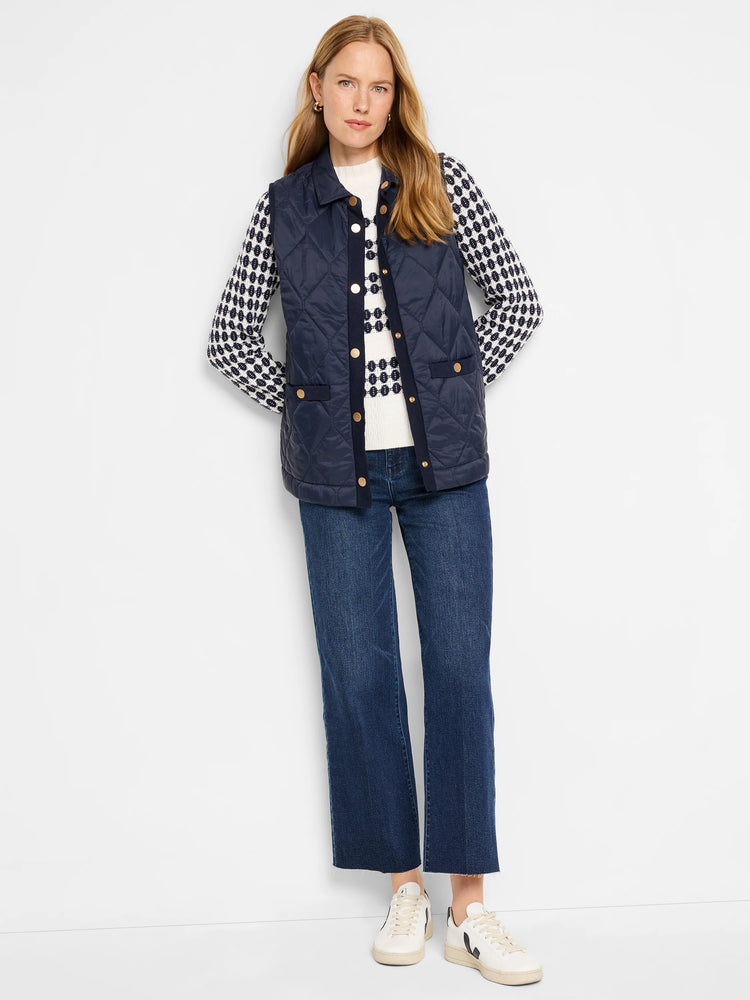Navy blue quilted puffer vest with gold buttons and pockets. Knit trim detail.