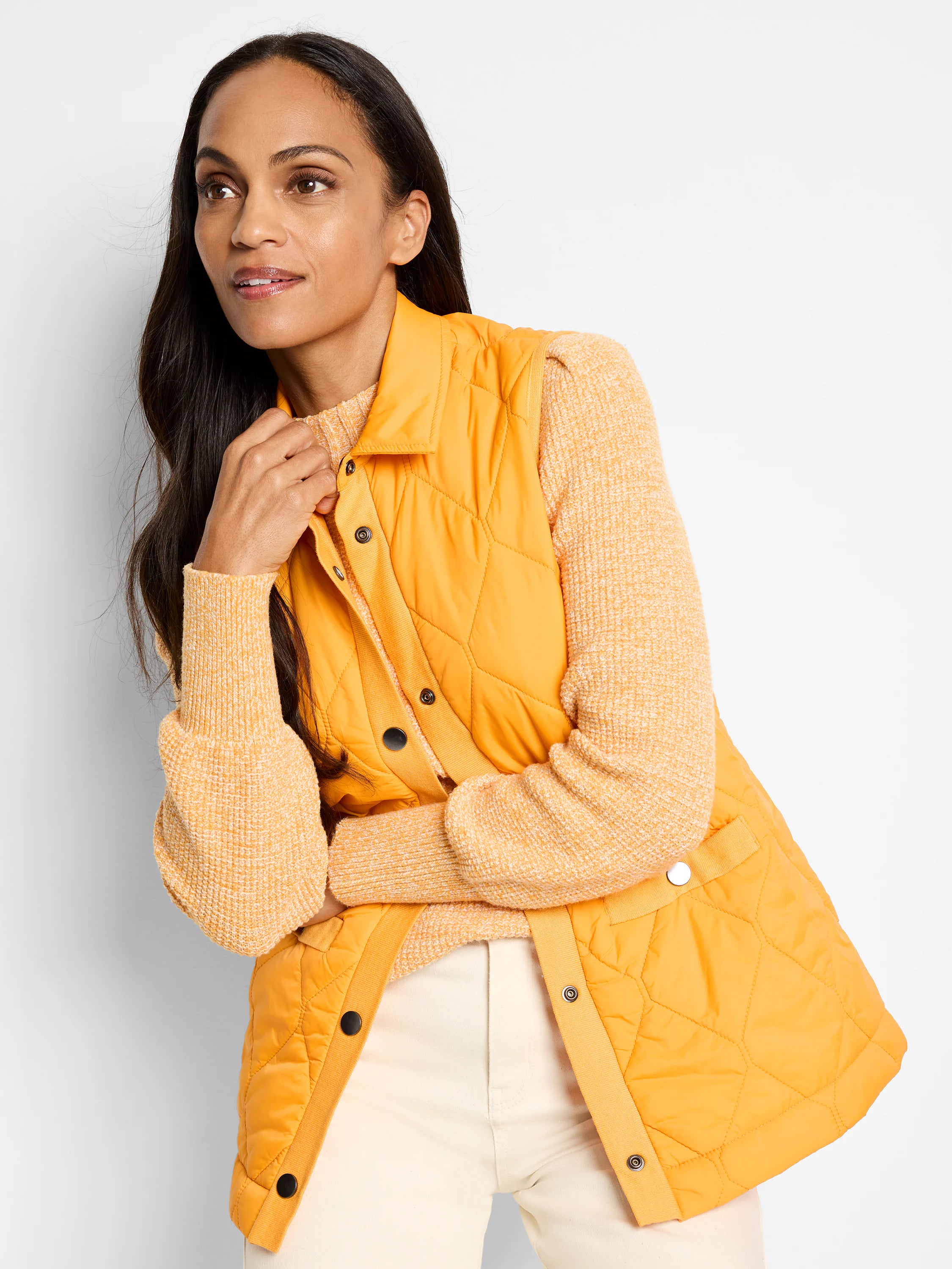 Mustard yellow quilted puffer vest with knit trim and dark buttons. Sleeveless.