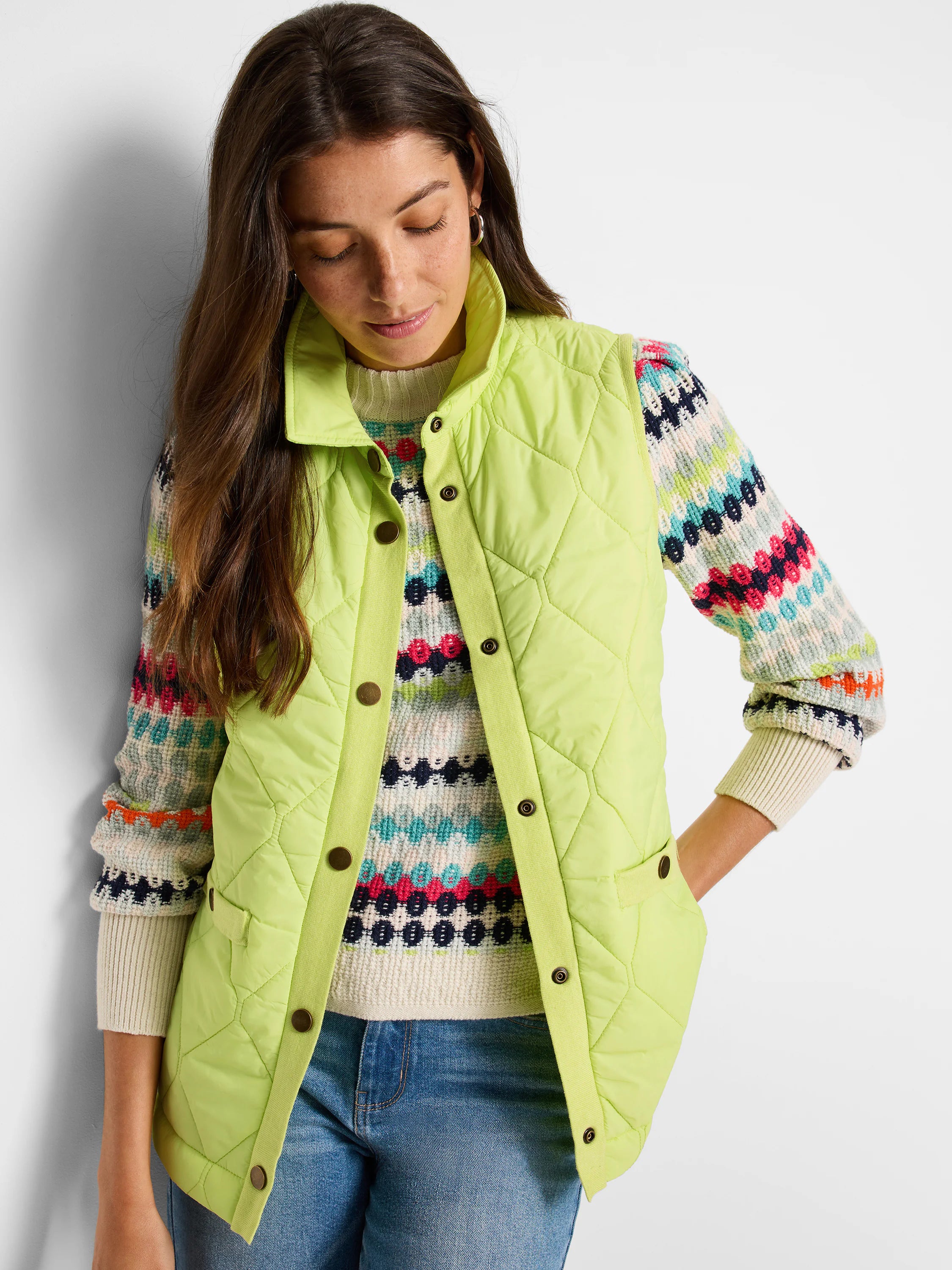 Lime green quilted puffer vest with a stand collar and dark bronze buttons. Features pockets.