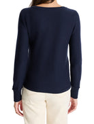 Back view of navy blue garter knit sweater with long sleeves, ribbed cuffs, hem, and crew neck.