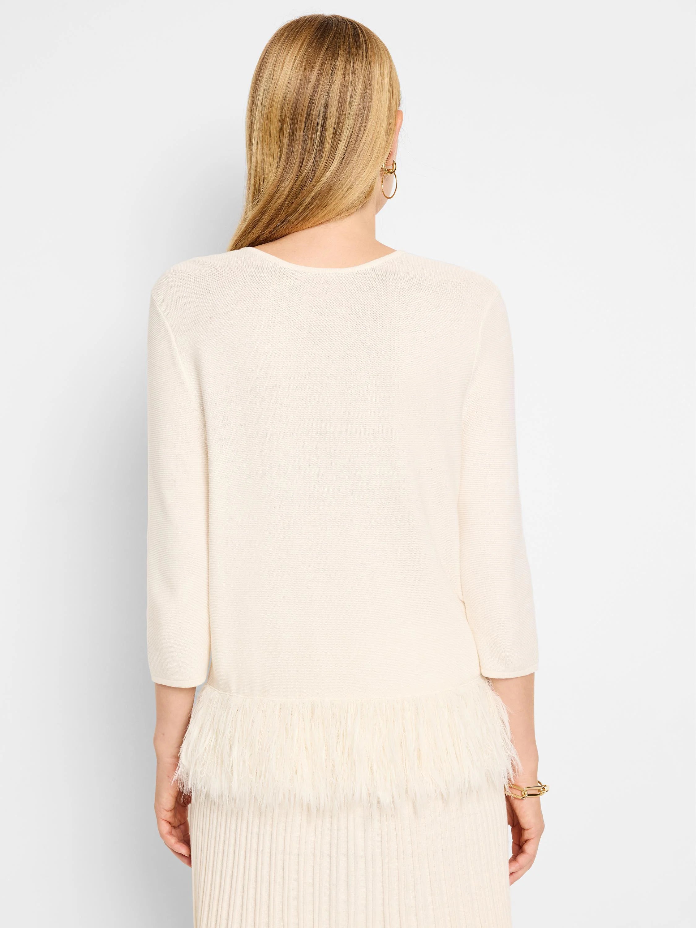 Off-white sweater, 3/4 sleeves. Bottom features a white feather fringe.