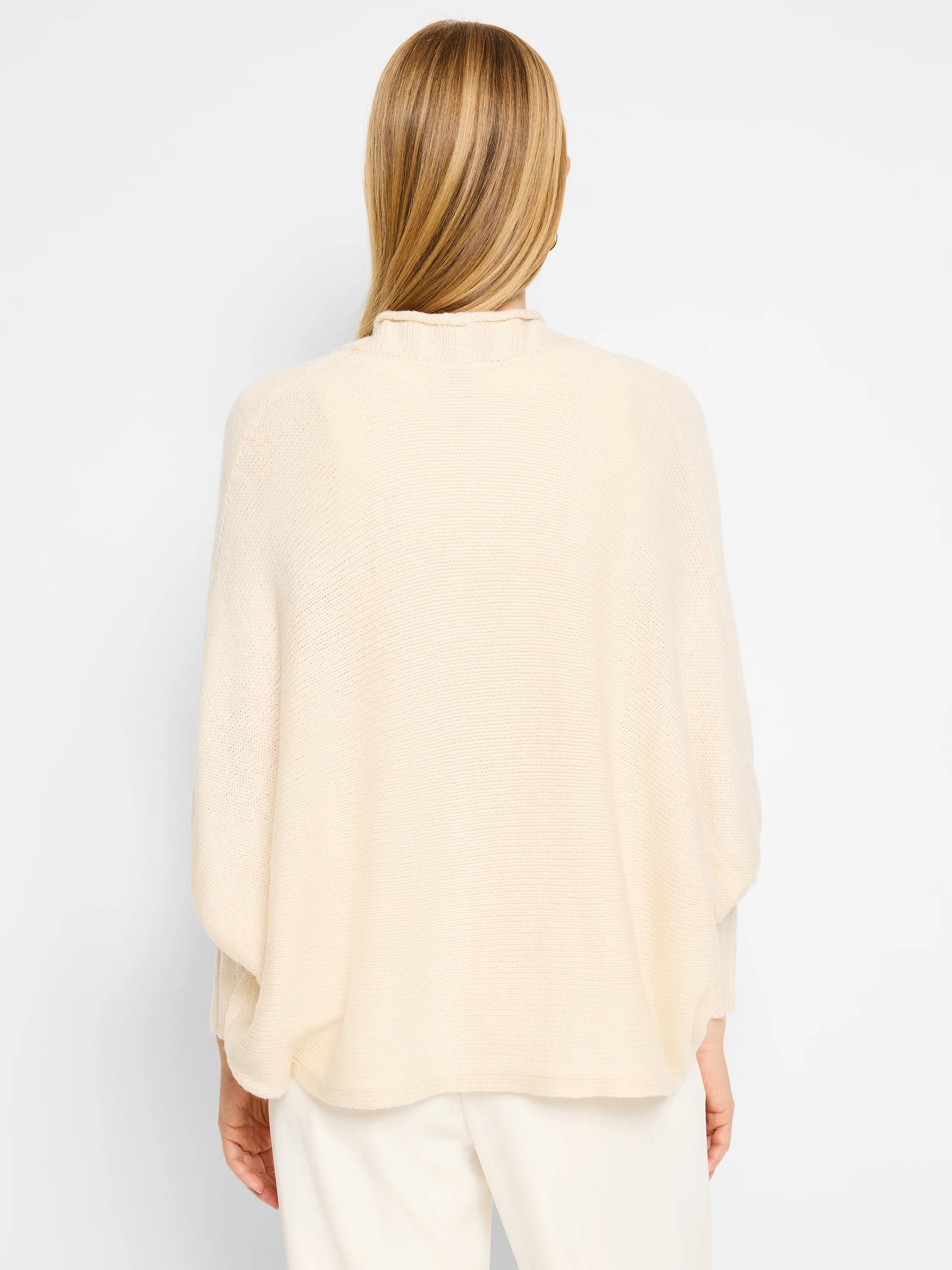 Cream-colored, oversized cardigan with a mock neck and long sleeves. Knit texture. Rear view.