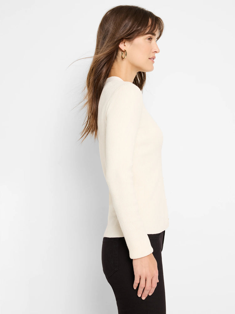 Off-white ribbed knit sweater, long sleeves. Profile view.