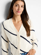 Cream-colored cardigan with diagonal navy stripes, V-neck, and button closure.