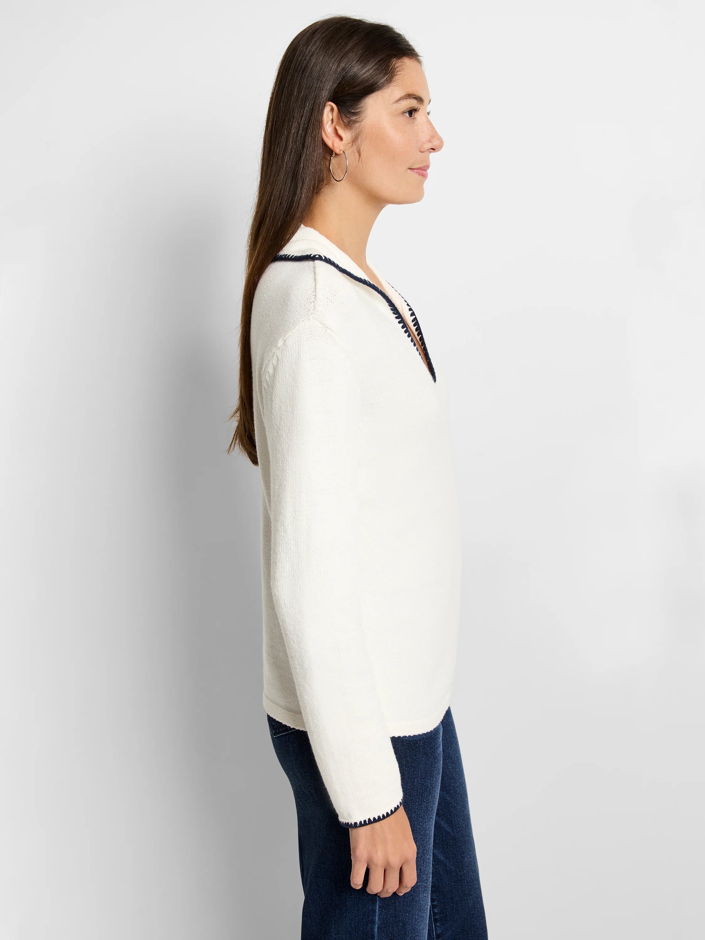 Off-white sweater with navy trim at collar and cuffs. Long sleeves, V-neck.