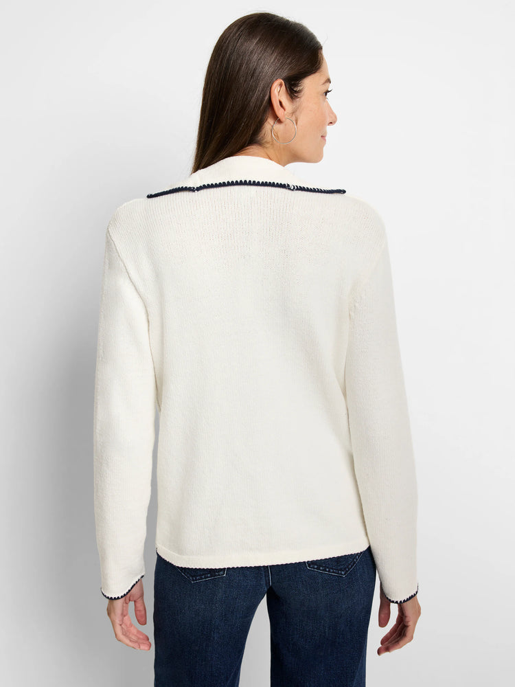 Off-white sweater with dark navy blanket stitch trim on collar and cuffs. Long sleeves.