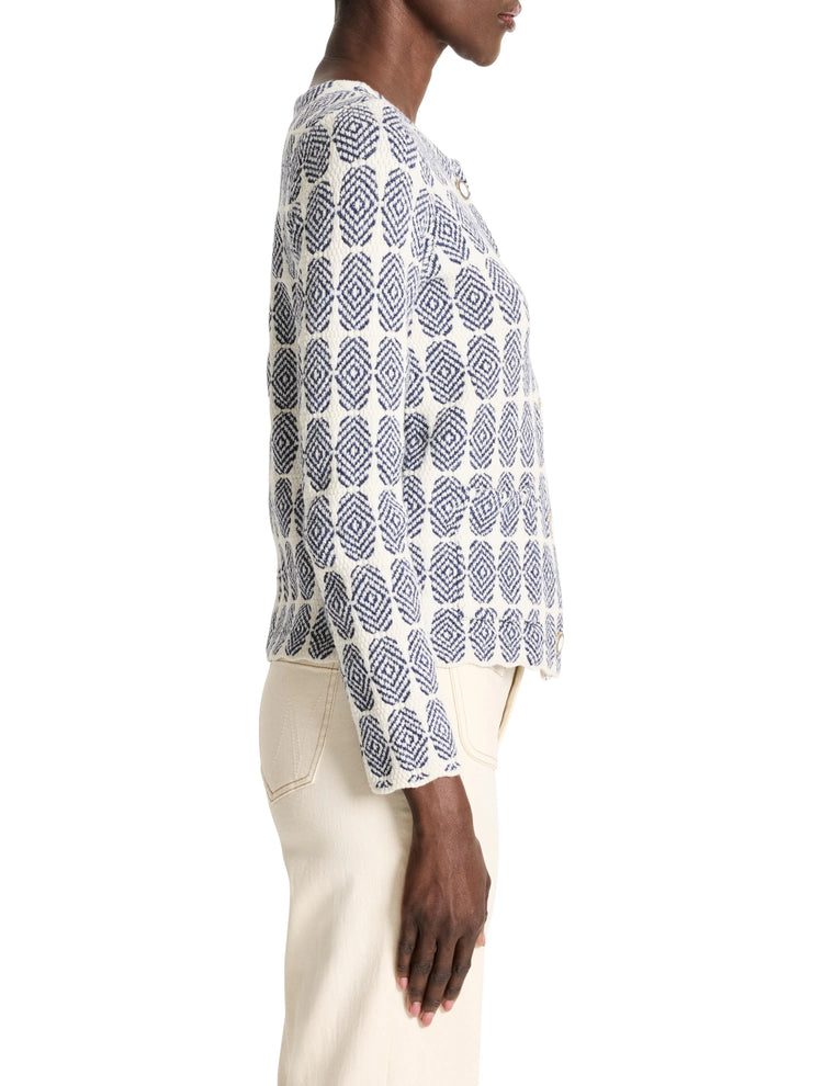 Off-white knit jacket with a navy blue geometric pattern. Side view.