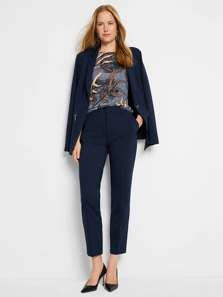 Midnight Fern Sweater: Blue-grey sweater with brown/beige abstract leaf print. Shown with navy blazer and pants.