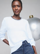 Light blue cotton cashmere sweater with a navy blue blanket stitch neckline.