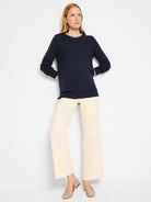 Navy blue sweater with a cream-colored stitched neckline.  Long sleeves, relaxed fit.