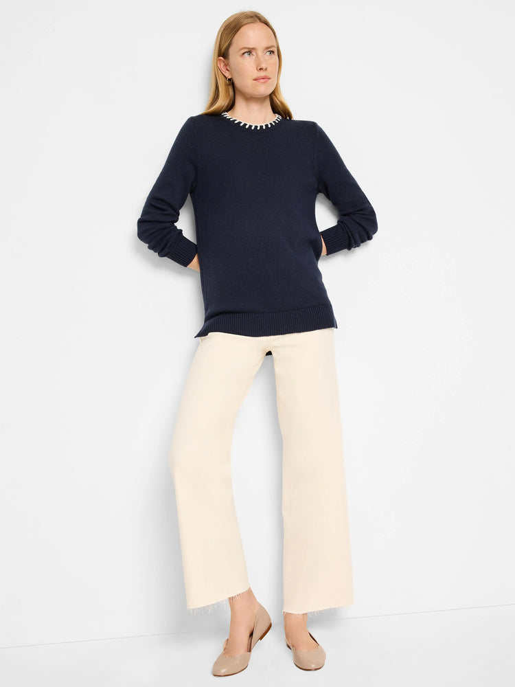 Navy blue sweater with a cream-colored stitched neckline. Long sleeves, relaxed fit.
