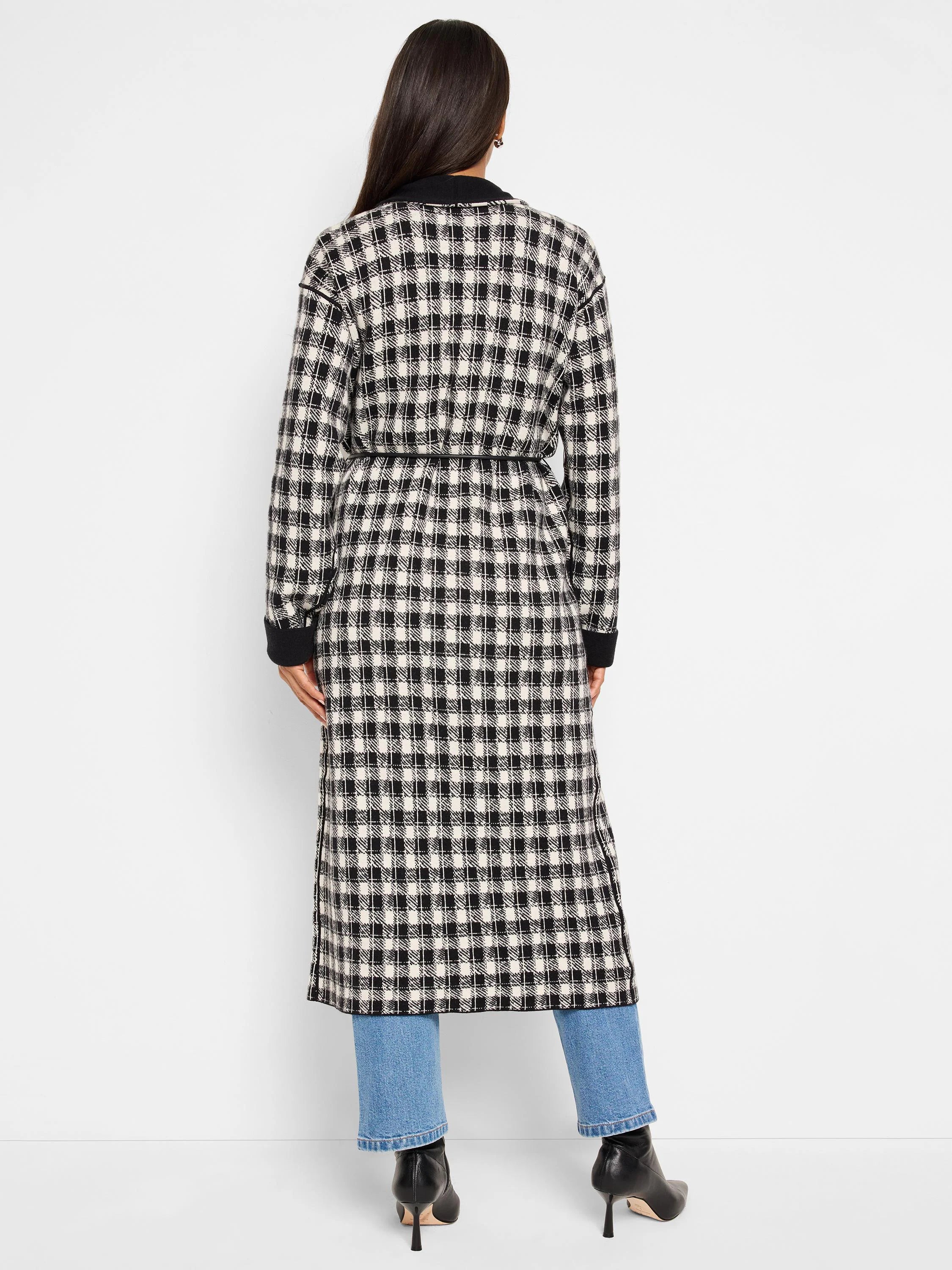 Black and off-white houndstooth long jacket with a self-tie belt; long sleeves and side slits.