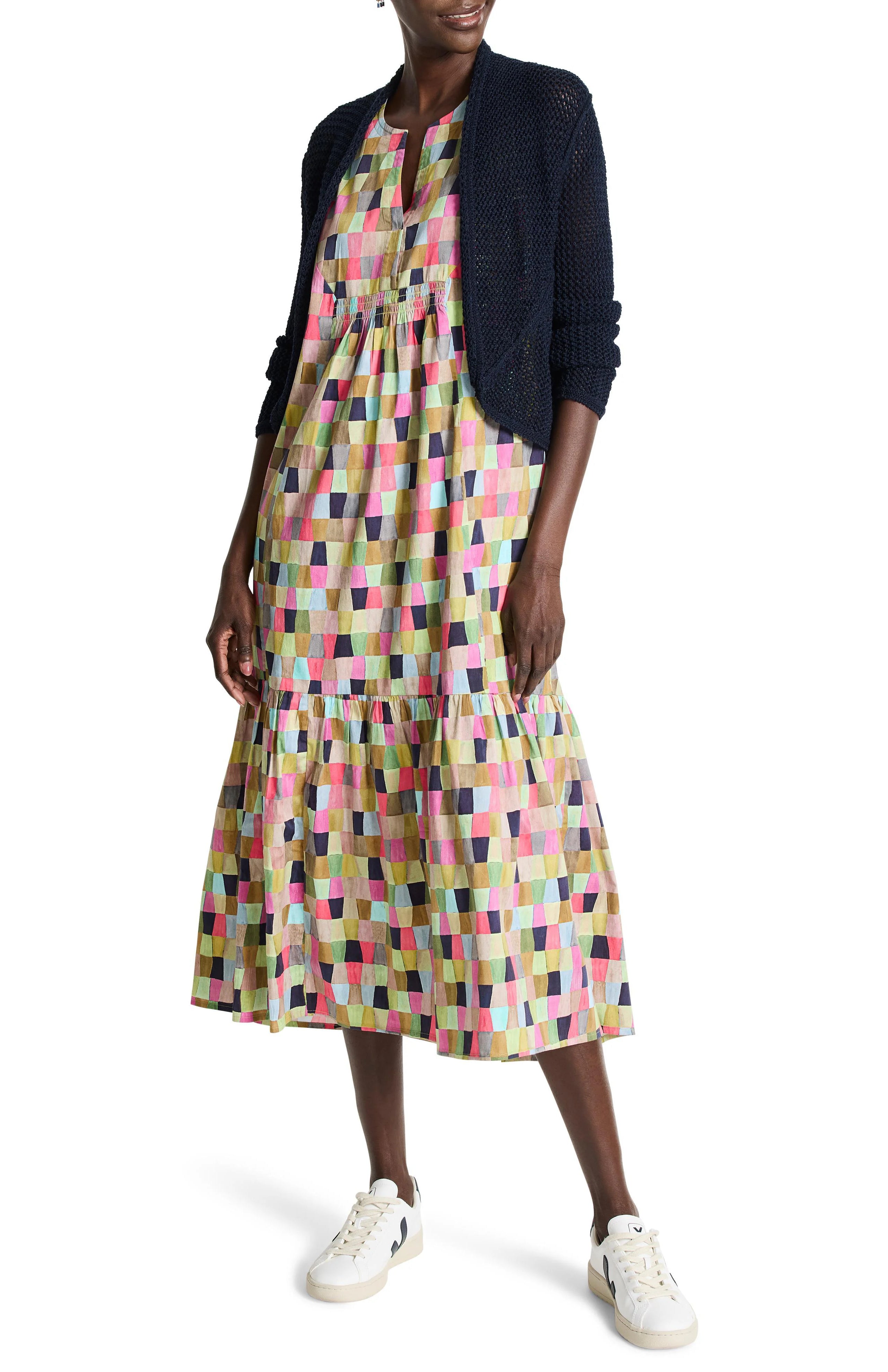 Navy blue open-front mesh cardigan over a multicolored, geometric-patterned midi dress.