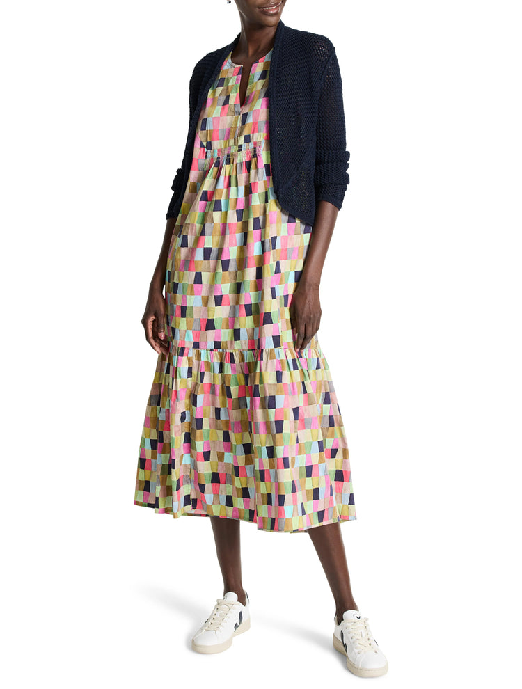 Navy blue open-front mesh cardigan over a multicolored, geometric-patterned midi dress.