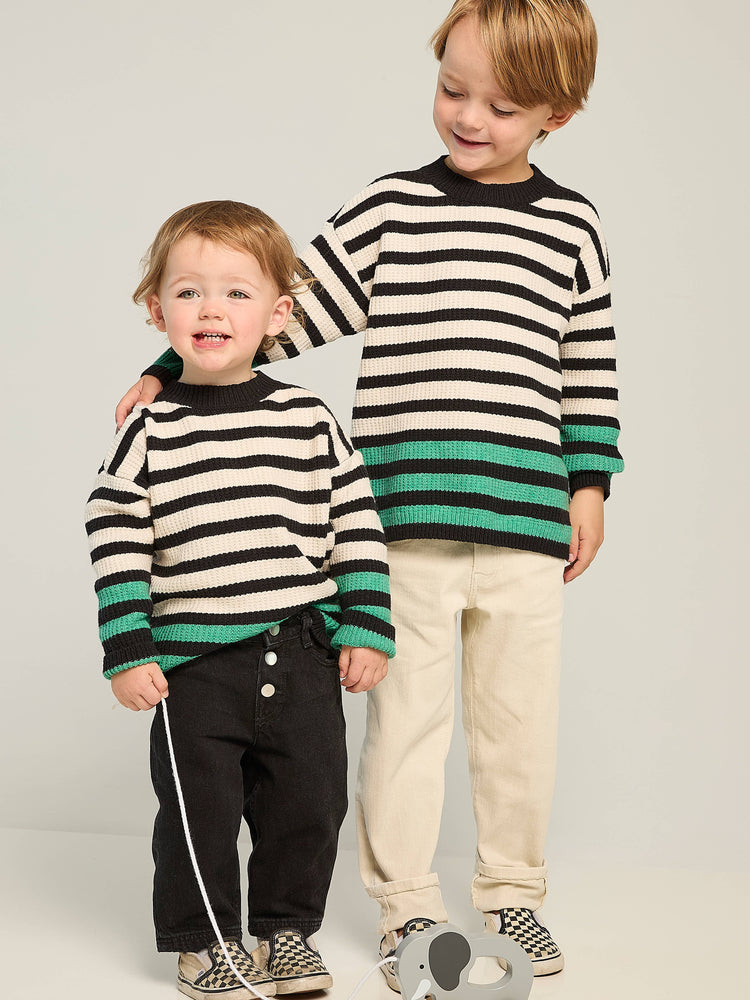 Cream and black horizontal striped waffle-knit sweater. Green stripes at cuffs and hem.