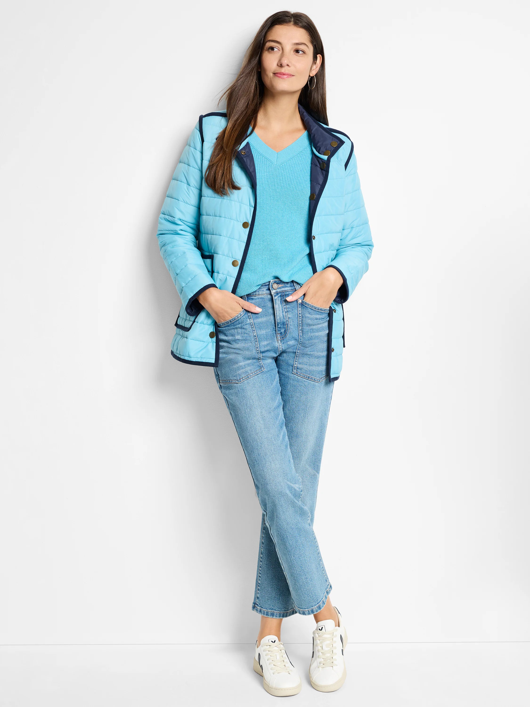 Aqua reversible puffer jacket with quilted texture, navy trim, and gold snap buttons.