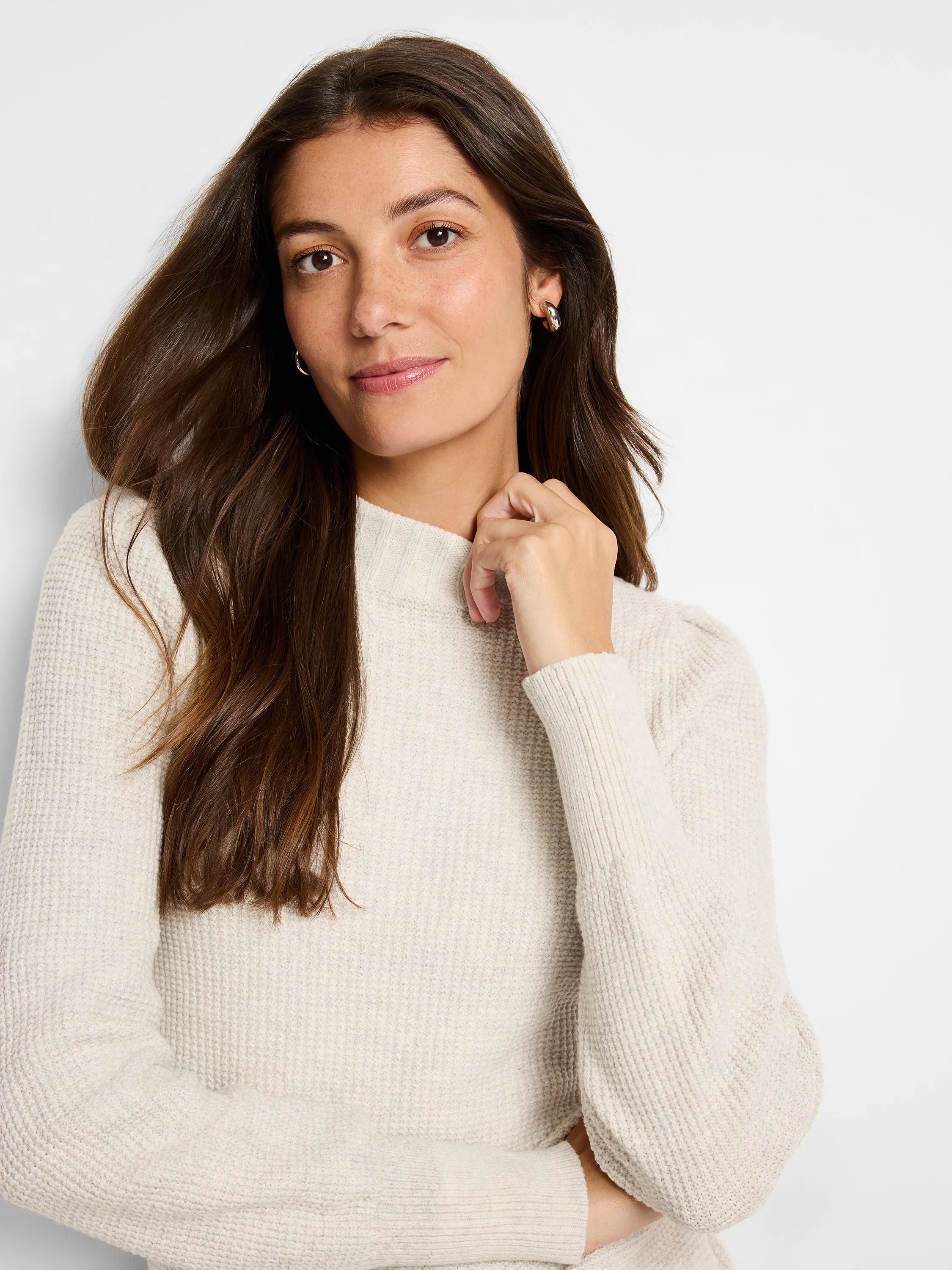 Cream waffle stitch sweater with a mock neck and ribbed cuffs.