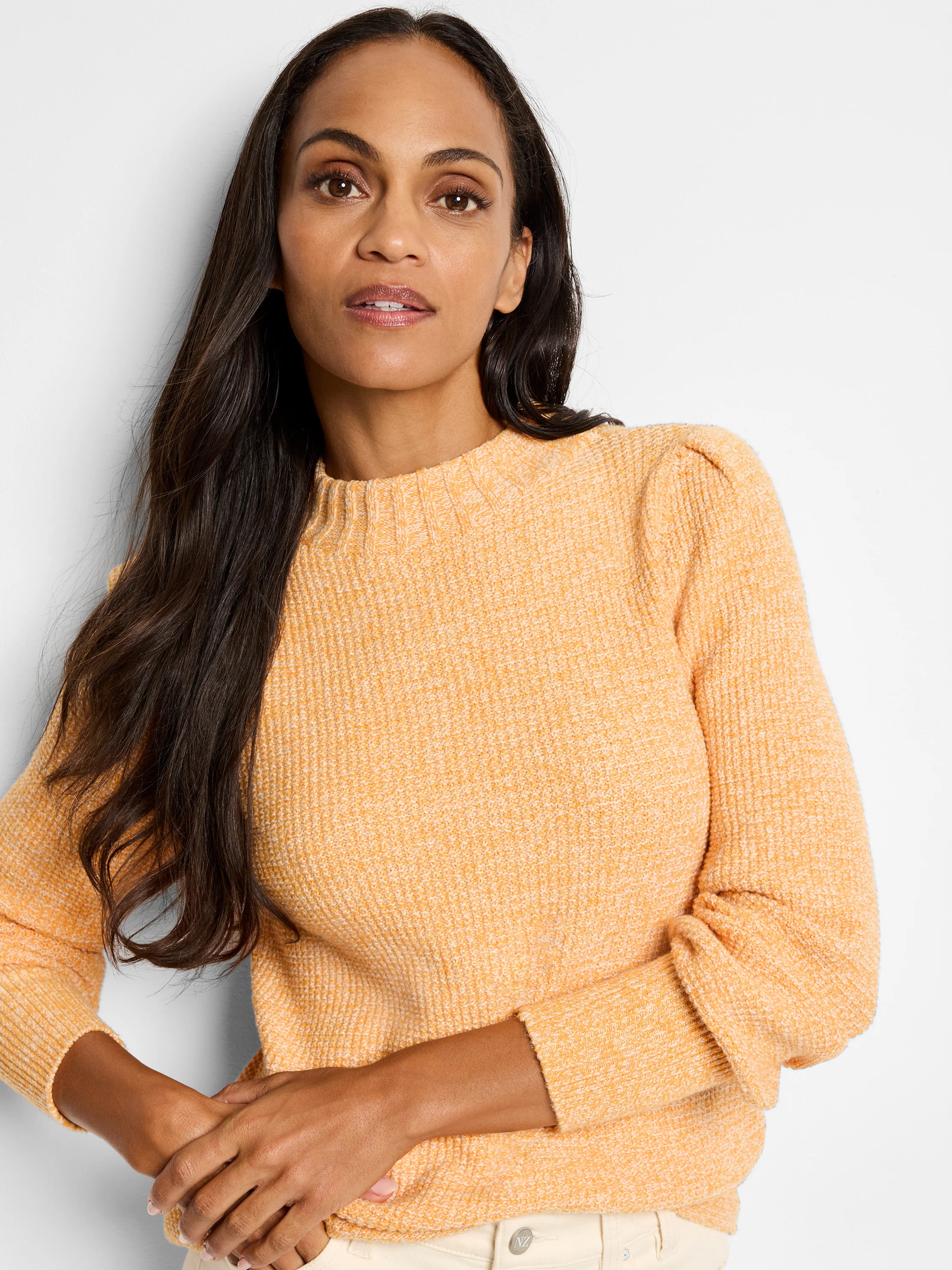 Peach waffle knit sweater with ribbed mock neck and puffed shoulders, worn by a woman.