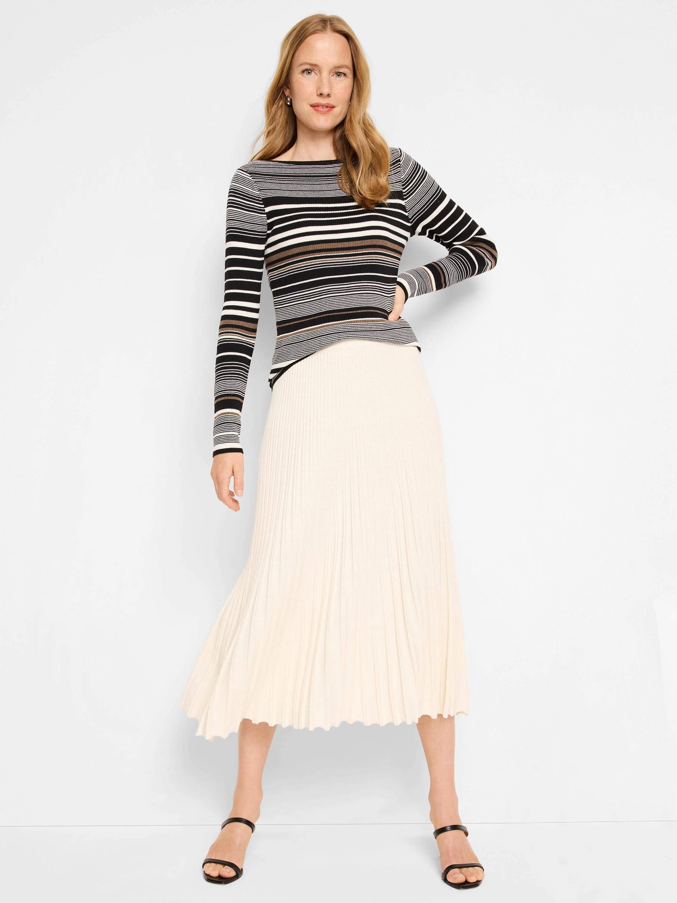 Ecru midi-length ribbed skirt with vertical pleats.