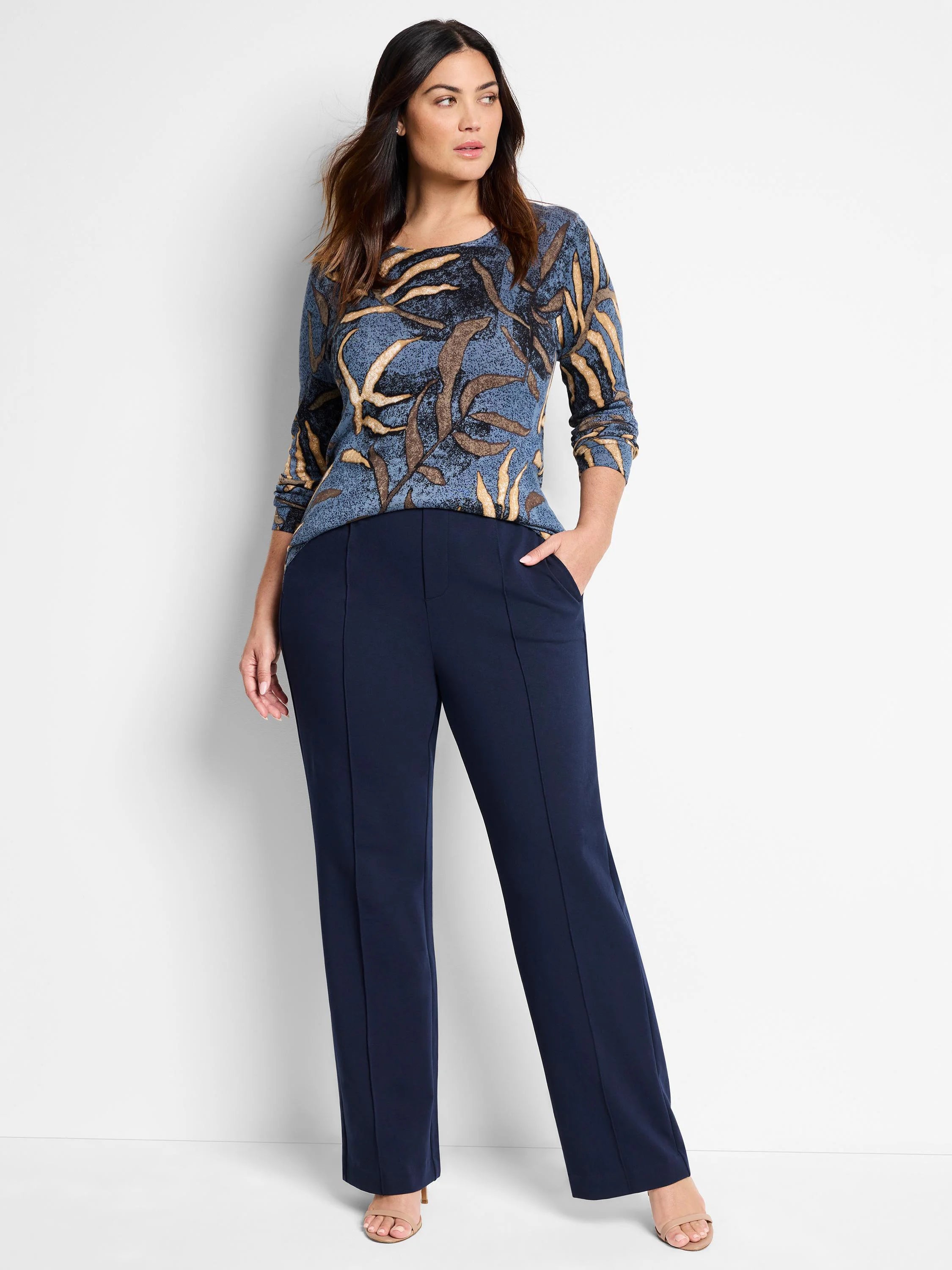 Navy blue wide-leg pleated pants; model wears them with a blue, brown, and gold patterned top.