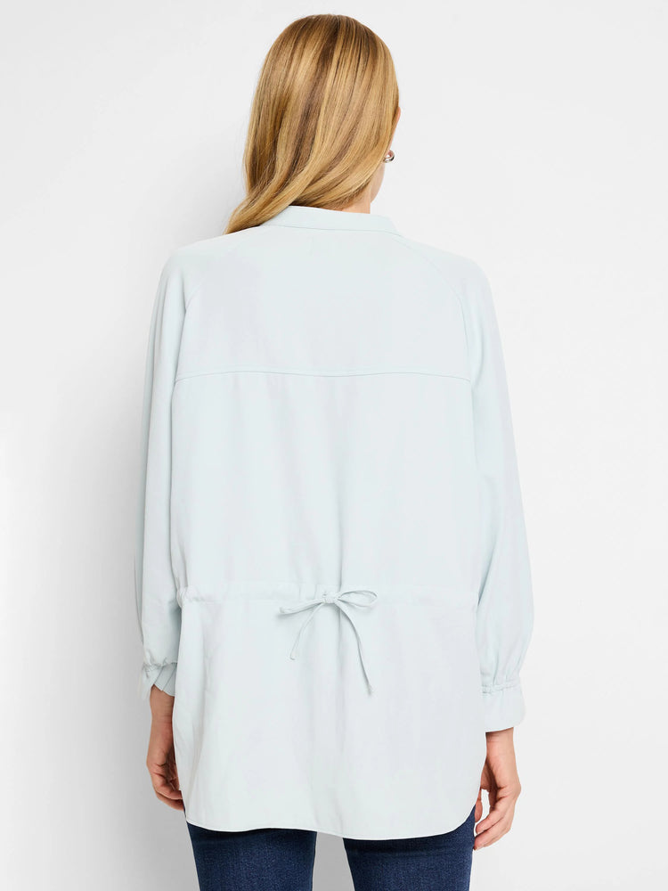 Light blue collared shirt with long sleeves and a drawstring waist. Back view.