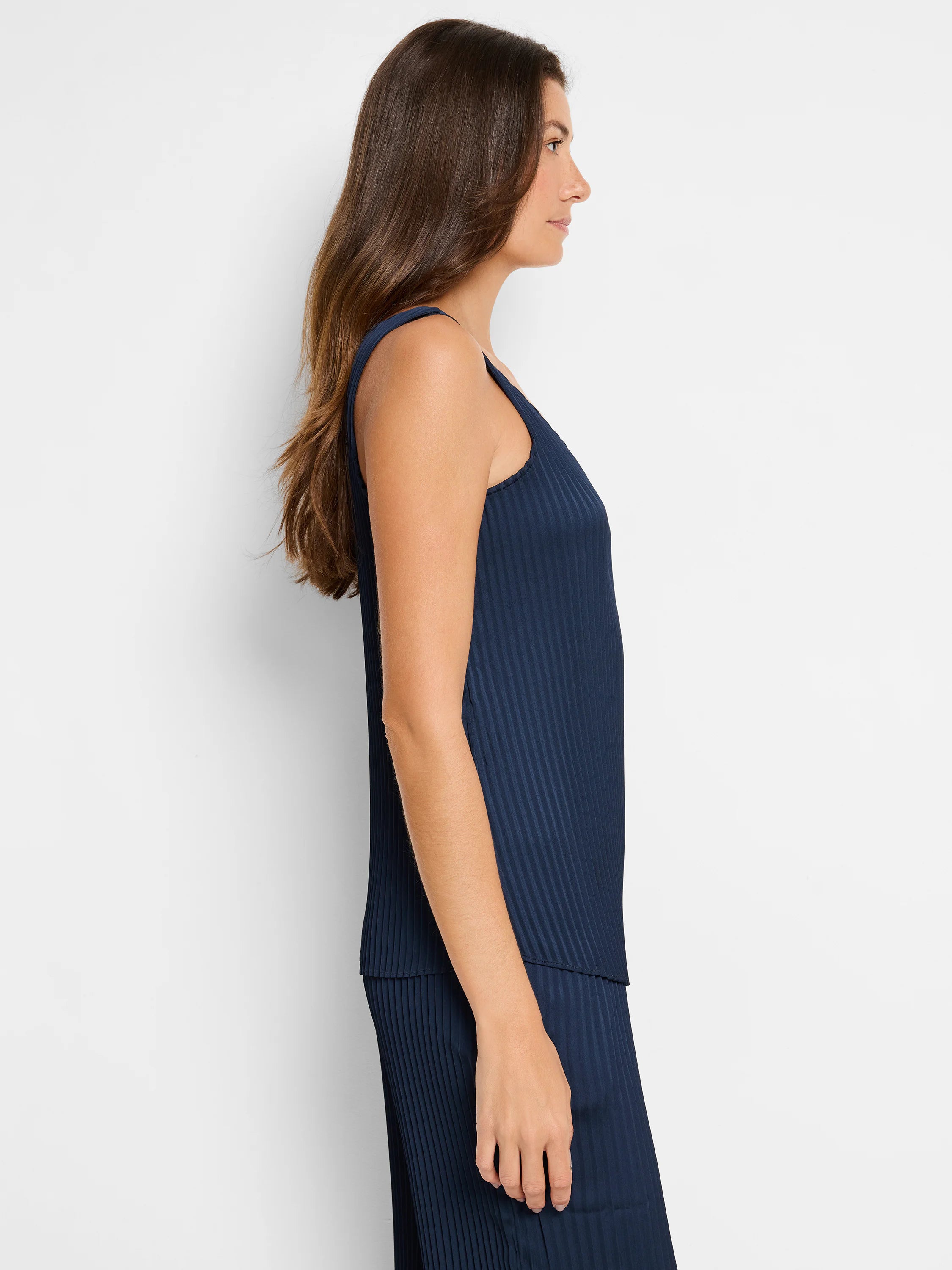 Navy blue sleeveless tank top with vertical pleats. Side profile view.