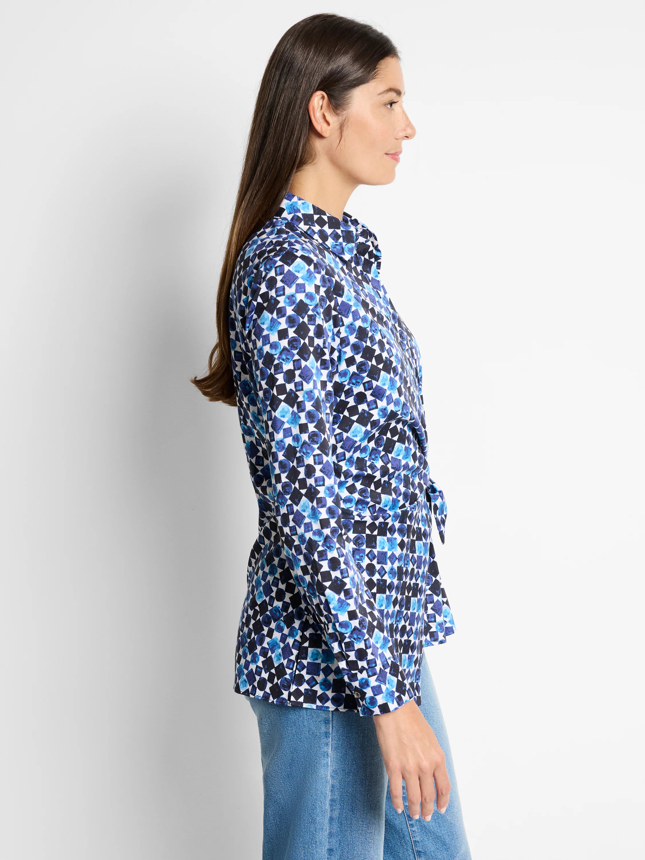 Side view of long-sleeve, blue and white patterned shirt with side tie. Geometric print includes dark and light blues.