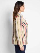 Beige top with vertical painted stripes: navy, red, olive, yellow, white. Features a collar, long sleeves, and breast pocket.