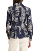Here's alt text that meets the criteria:
"Dark navy blue shirt with off-white zebra stripes.  Long sleeves, collared.