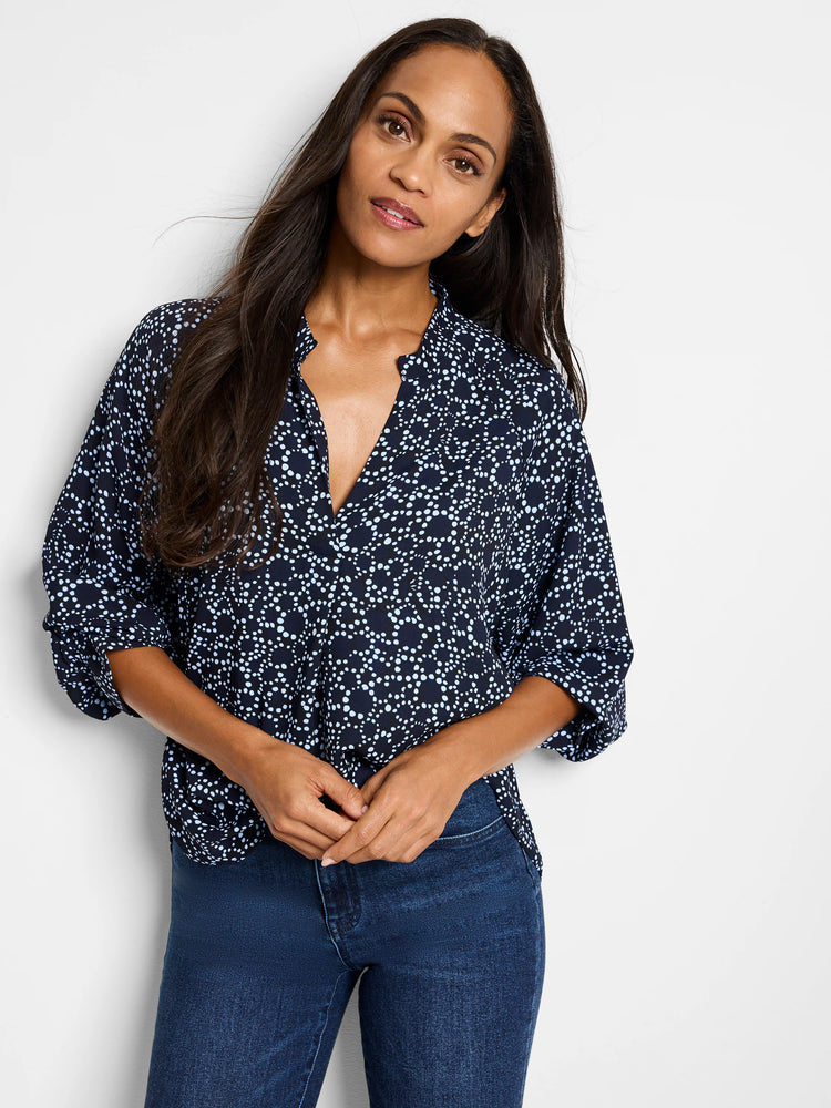 Navy blue top with a light blue and white dot pattern. Three-quarter sleeves, v-neck.