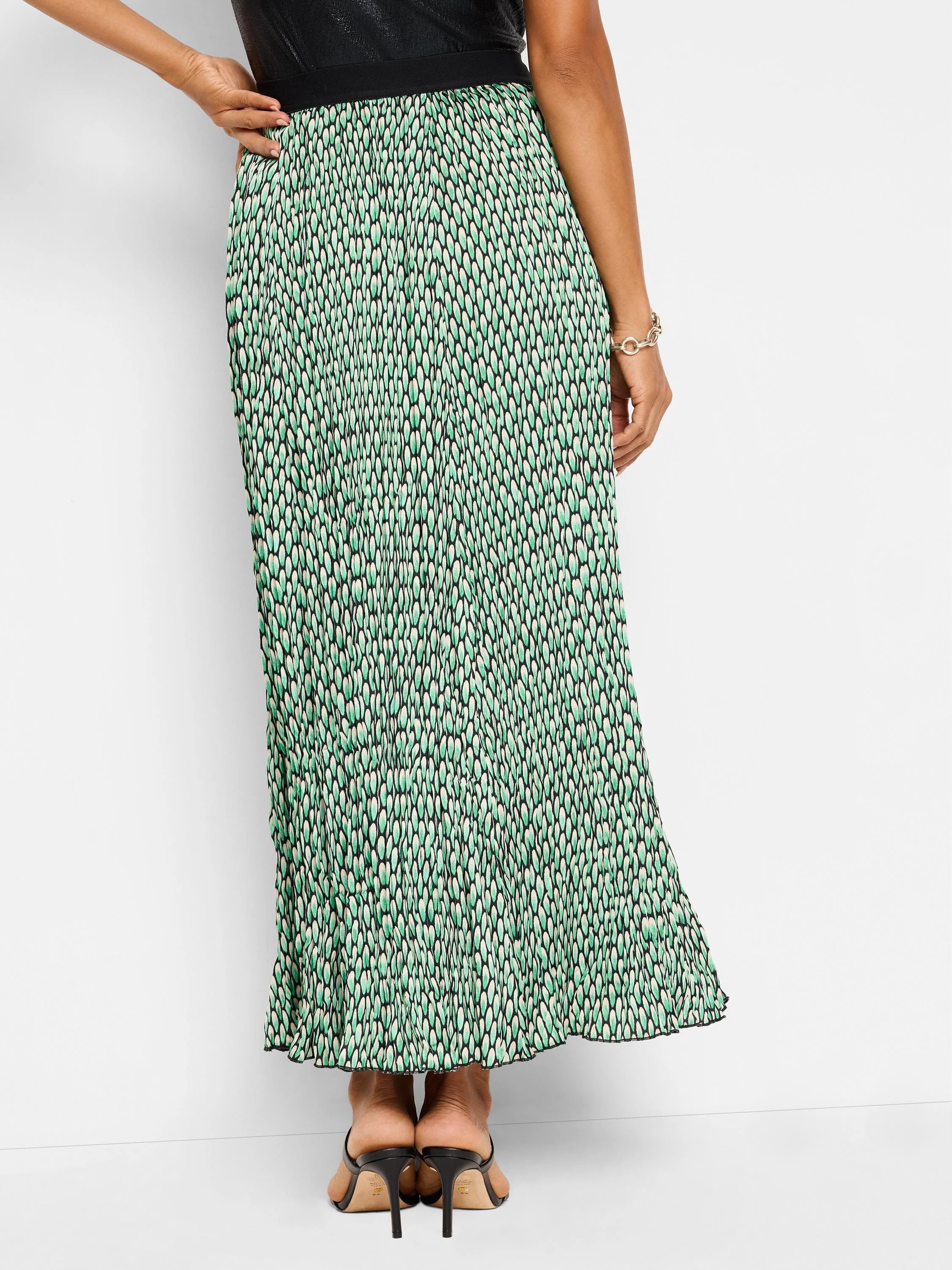 Pleated maxi skirt in green, black, and white abstract dot print.