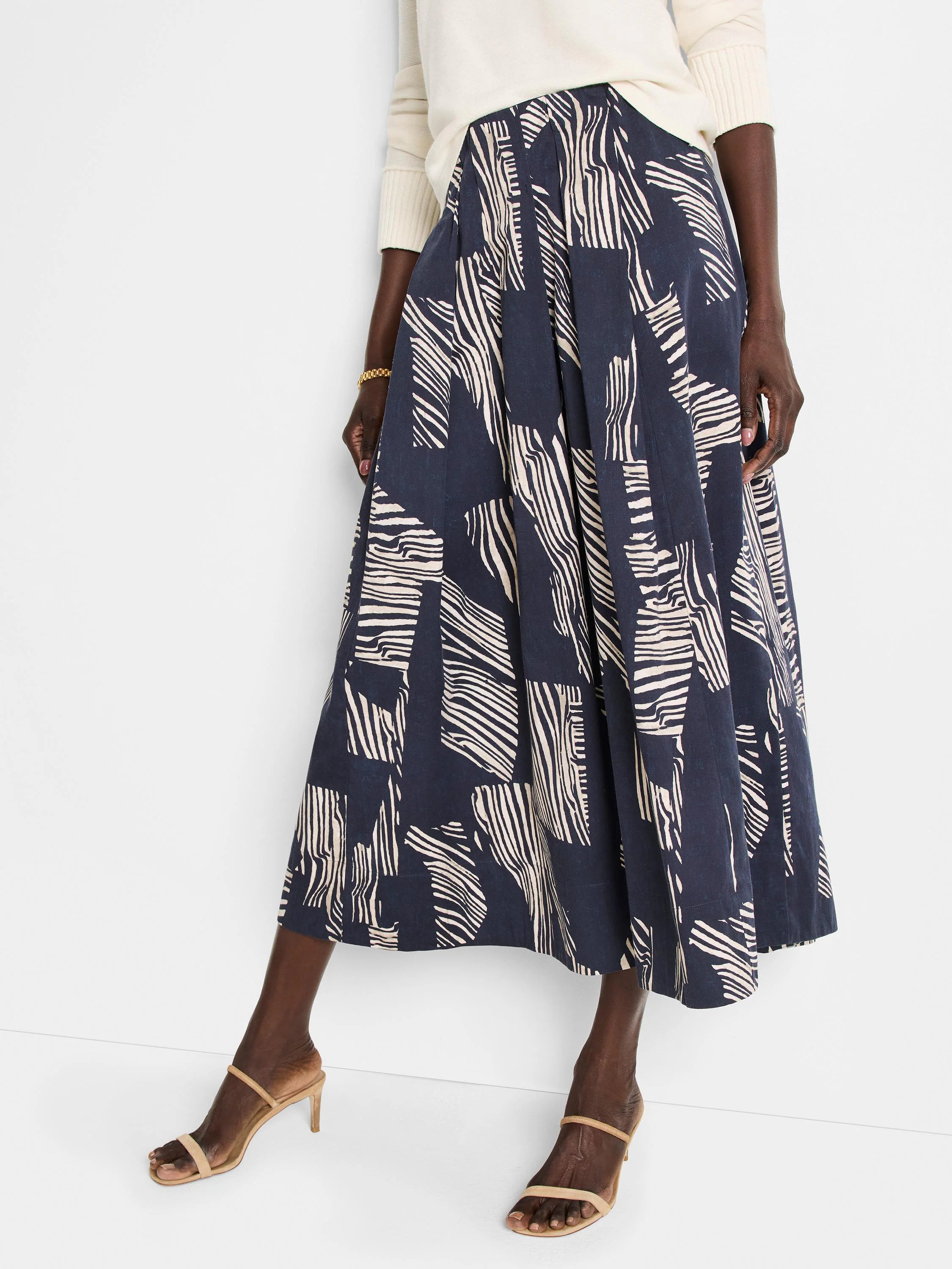 Midi pleated skirt in navy blue with an off-white zebra stripe pattern.