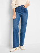 Medium blue high-rise wide-leg jeans featuring two prominent, rounded patch pockets on the front.