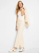 Cream wide-leg jeans with a frayed, cropped hem.