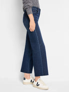 Dark blue wide leg jeans, cropped at ankle, with light fading on seams and a raw hem.