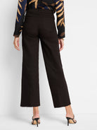 Dark wide-leg cropped jeans with frayed hems and visible back pockets, worn from behind.