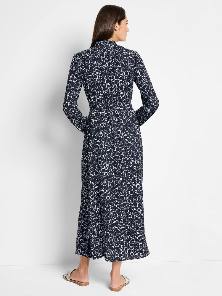 Navy maxi dress with light blue and white dot pattern, long sleeves, collared neckline. Back view.