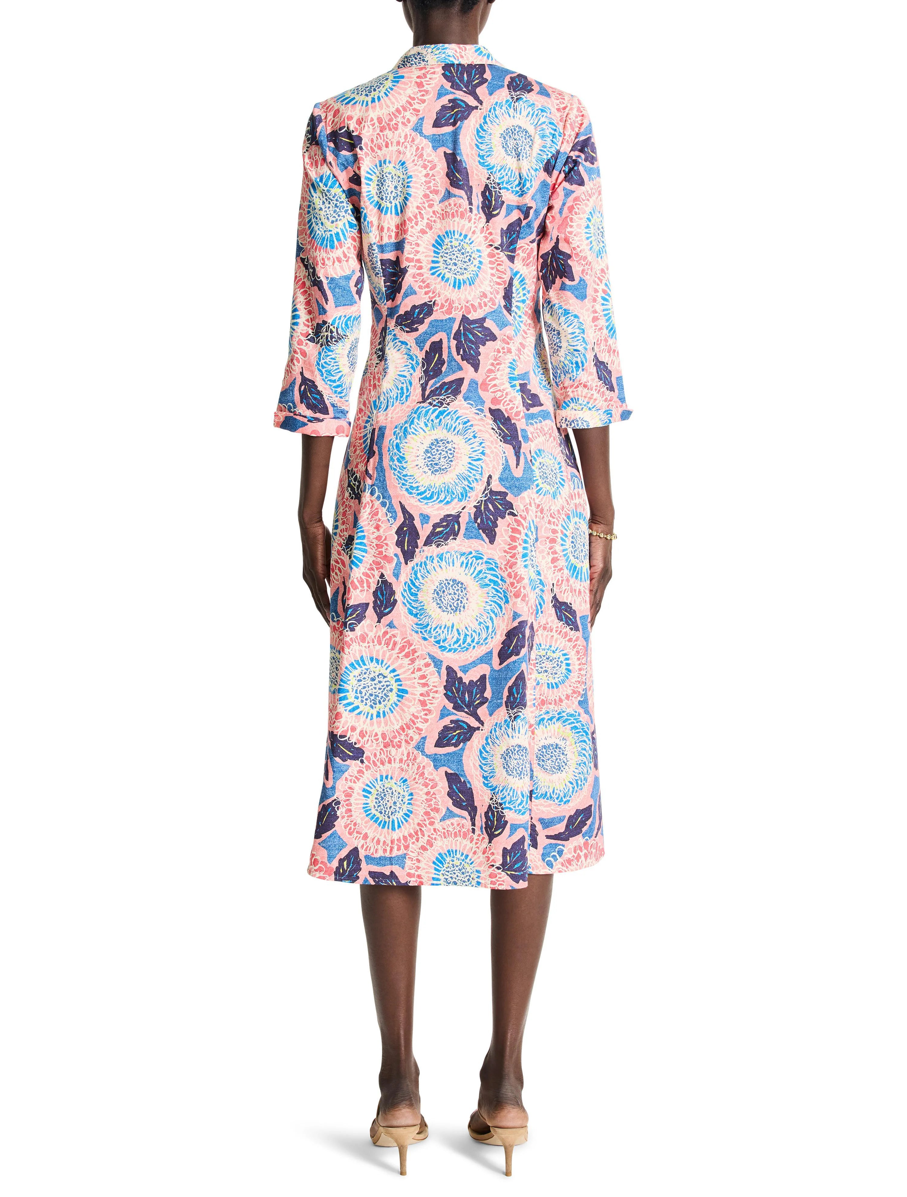 Pink midi shirt dress with blue, white, and dark purple floral print. Three-quarter sleeves.