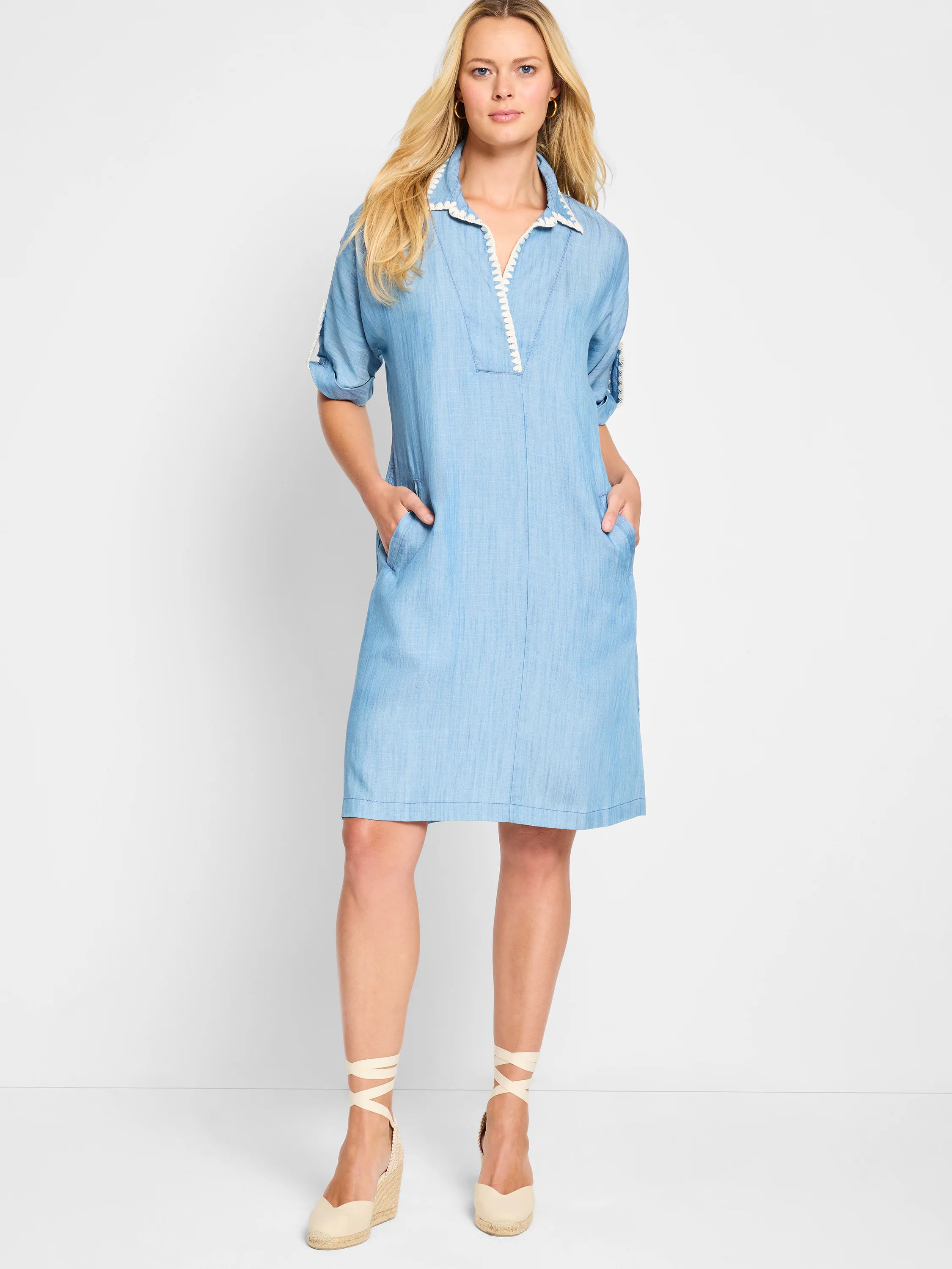 Light blue denim dress, short sleeves, collared neckline with white trim, and pockets.