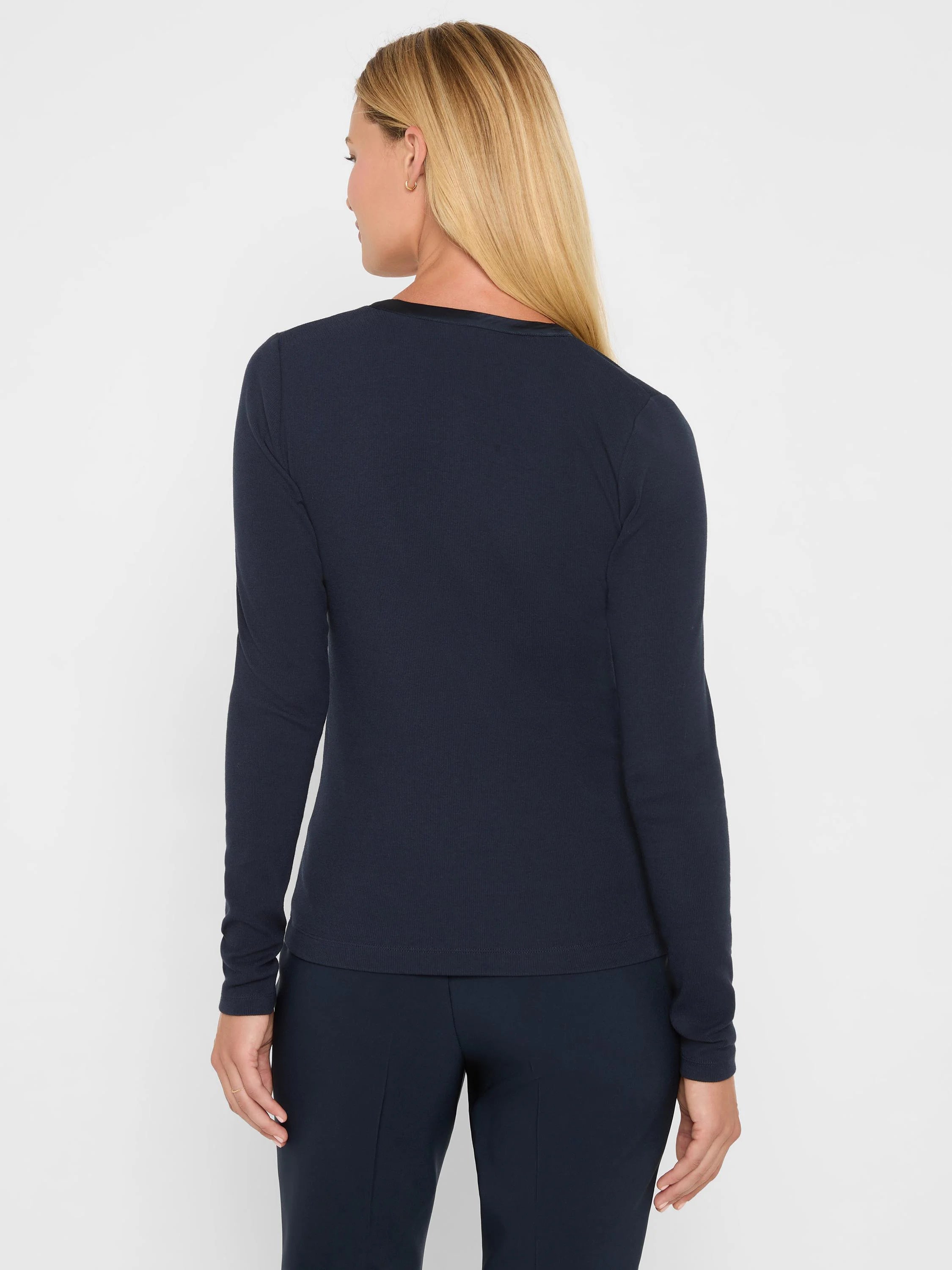 Navy ribbed long-sleeve knit top, back view. Rounded neckline features a shiny trim.