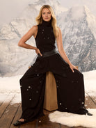 Black ribbed knit turtleneck tank. Sleeveless top shown on model.