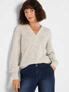 Light beige nep knit top with silver sparkle, V-neck, and long gathered sleeves with cinched cuffs.