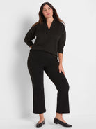 Black V-neck top with long sleeves and fine horizontal gold sparkle stripes.