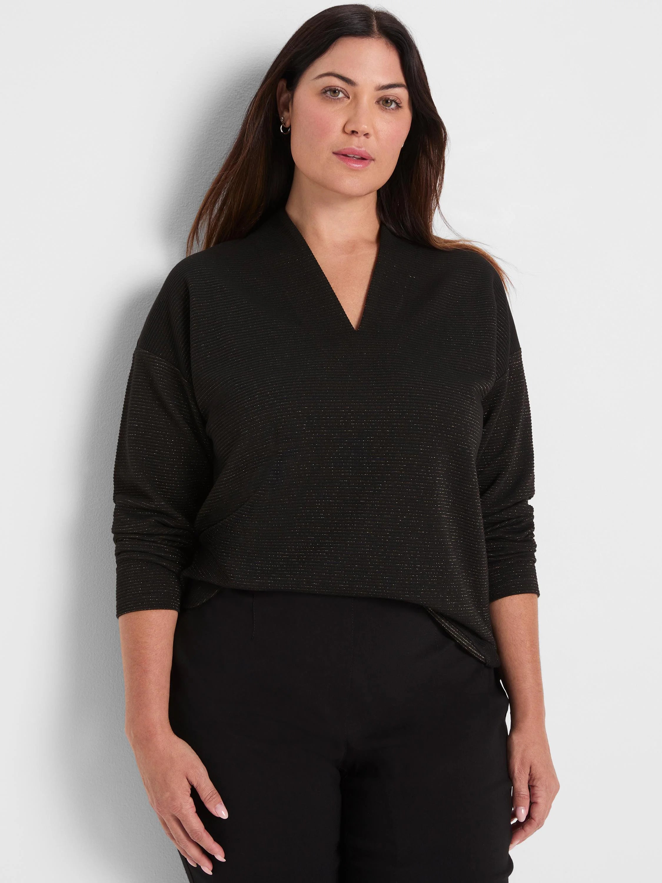 Black top featuring sparkling horizontal stripes, ribbed texture, a notched V-neck, and long sleeves.
