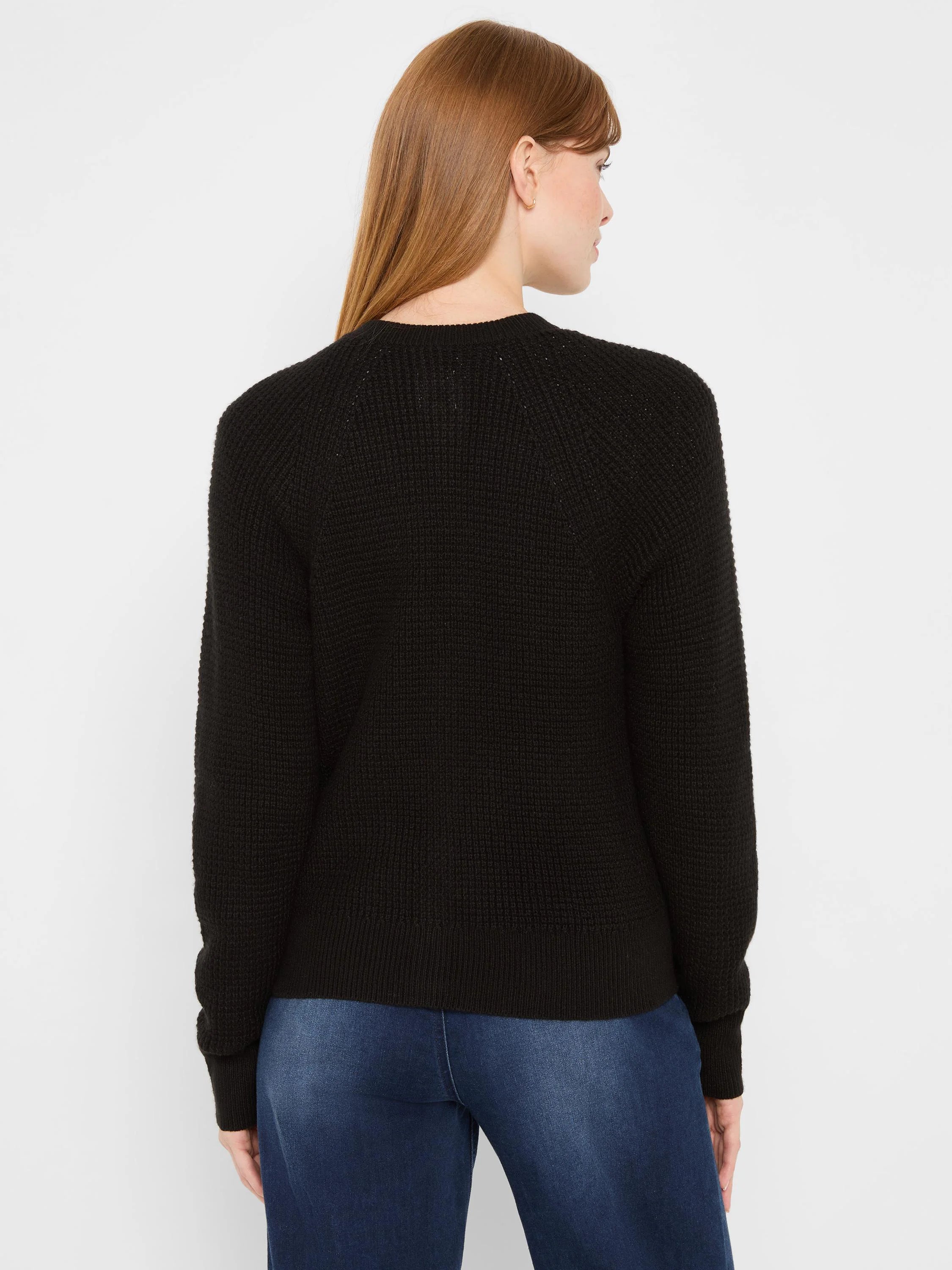 Black waffle tuck knit cardigan. Back view with long sleeves, ribbed cuffs & hem.