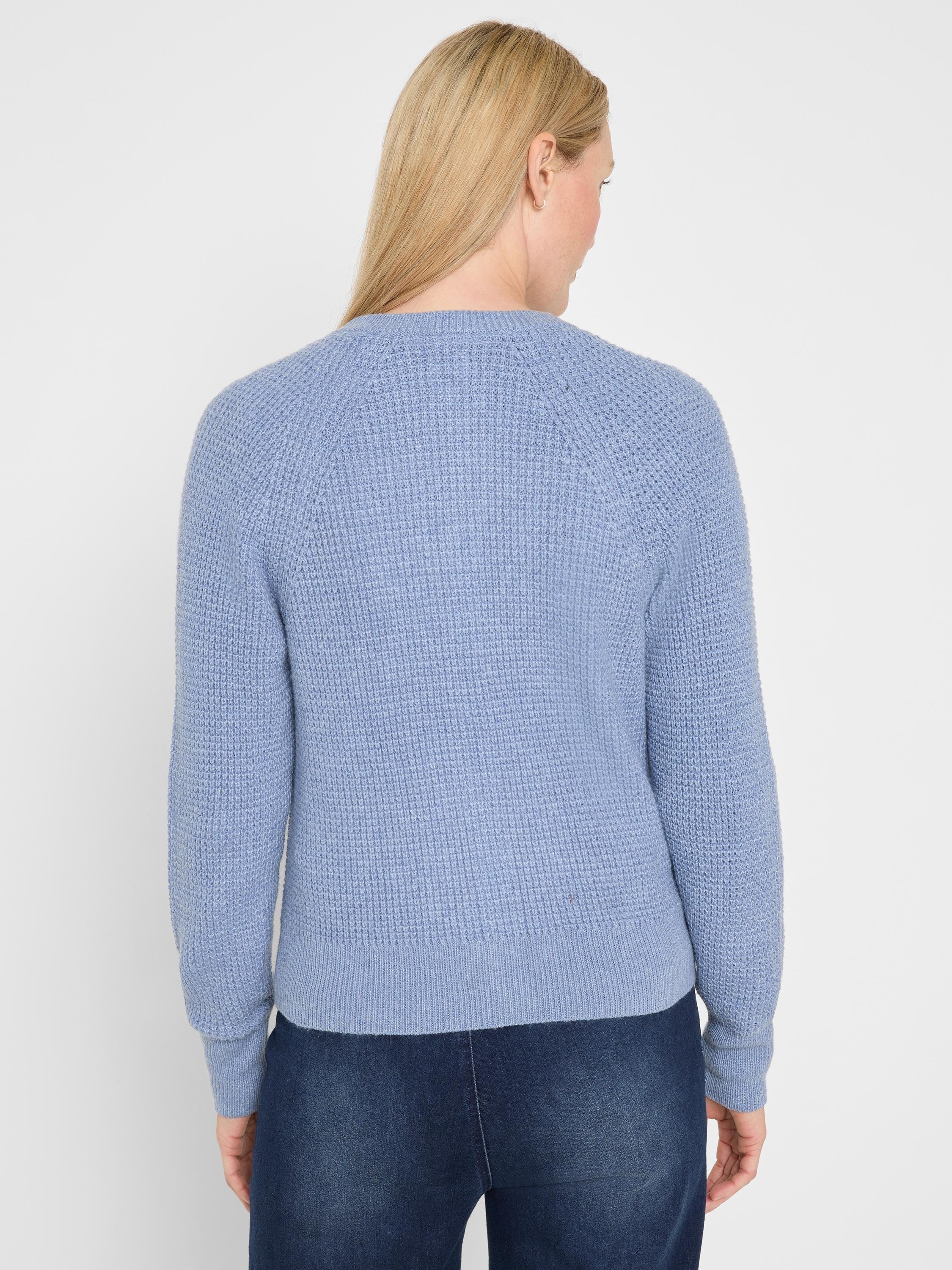 Light blue waffle-knit cardigan, back view. Features raglan sleeves, ribbed cuffs, and hem.