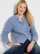 Periwinkle blue waffle knit cardigan with a crew neck and light buttons, shown on a model.