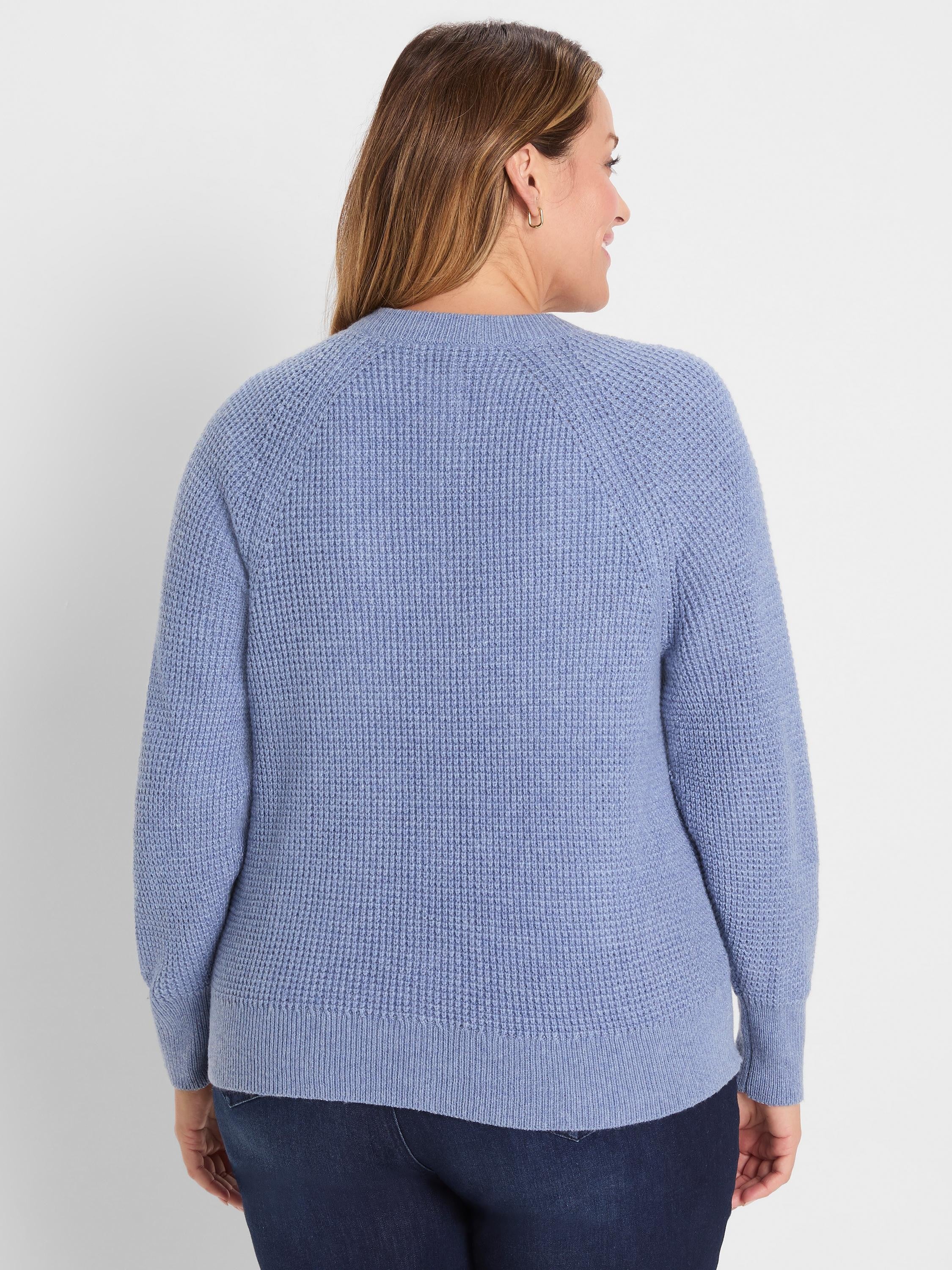 Dusty blue waffle tuck knit cardigan on woman, back view. Features raglan sleeves and ribbed hem/cuffs.