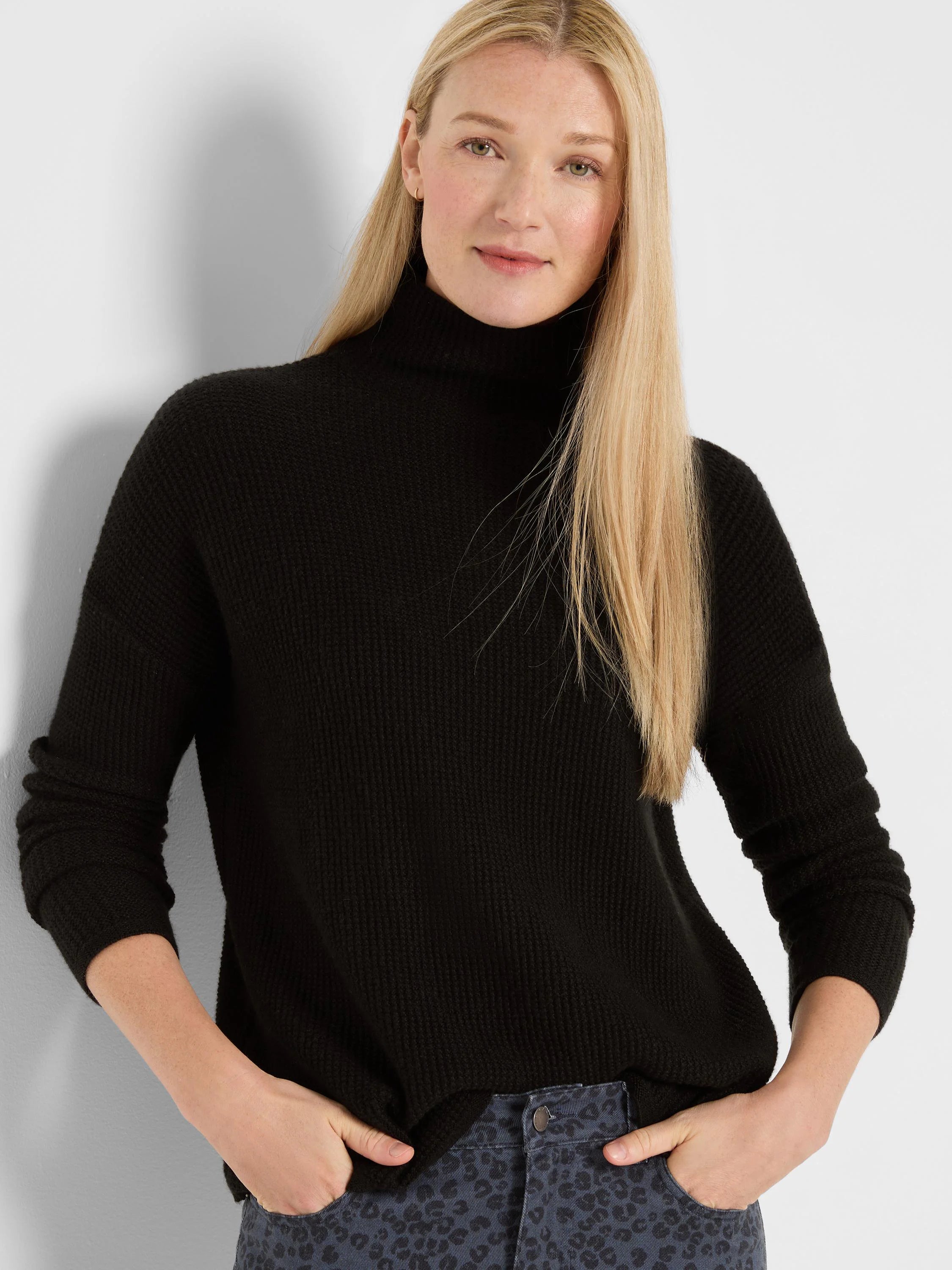 Black waffle knit turtleneck sweater, relaxed fit.